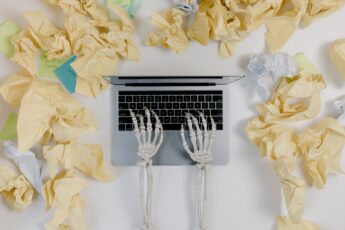 Skeleton hands typing on laptop
